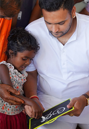 Man interacting with a child holding a slate